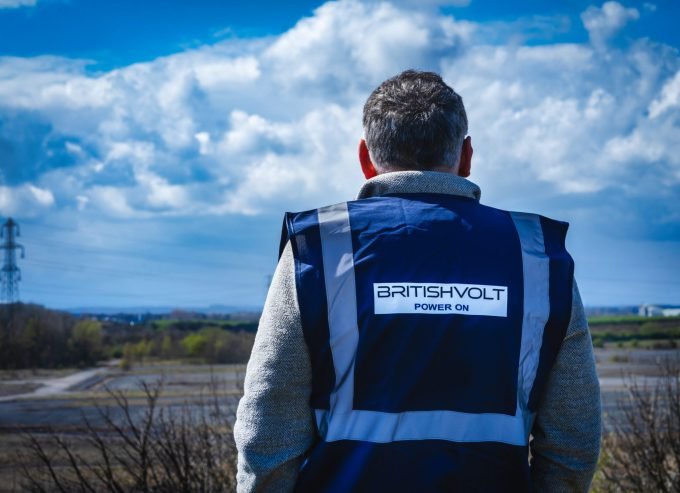 Man in Britishvolt vest looks out at construction site.